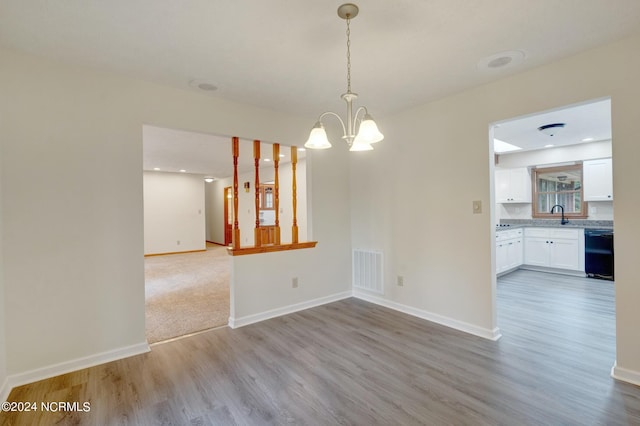 spare room featuring a notable chandelier, sink, and wood-type flooring