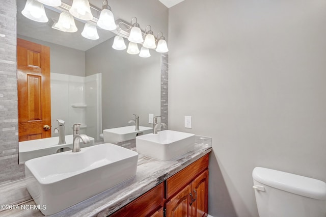 bathroom with dual bowl vanity and toilet