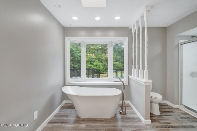 bathroom with a bathtub, hardwood / wood-style floors, and toilet