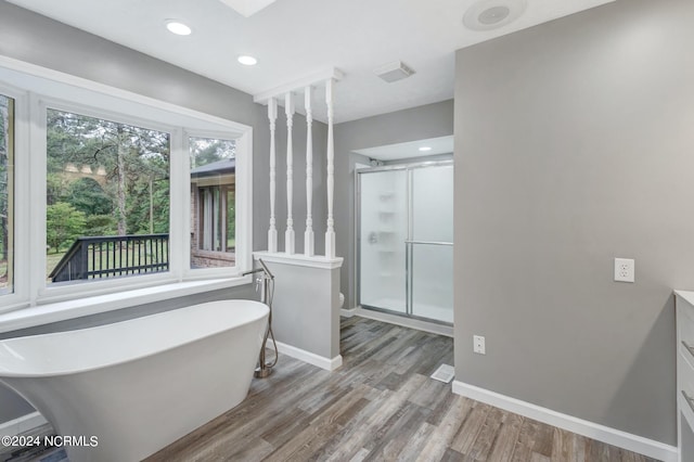 bathroom with walk in shower, hardwood / wood-style floors, and vanity