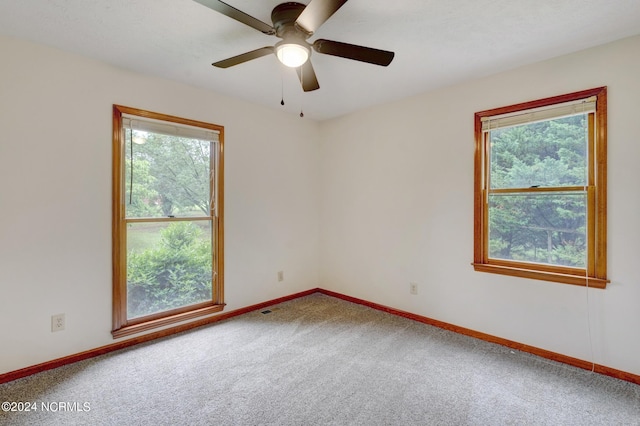 carpeted spare room featuring ceiling fan