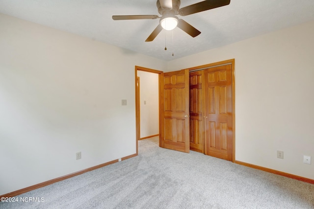 unfurnished bedroom featuring light carpet, a closet, and ceiling fan