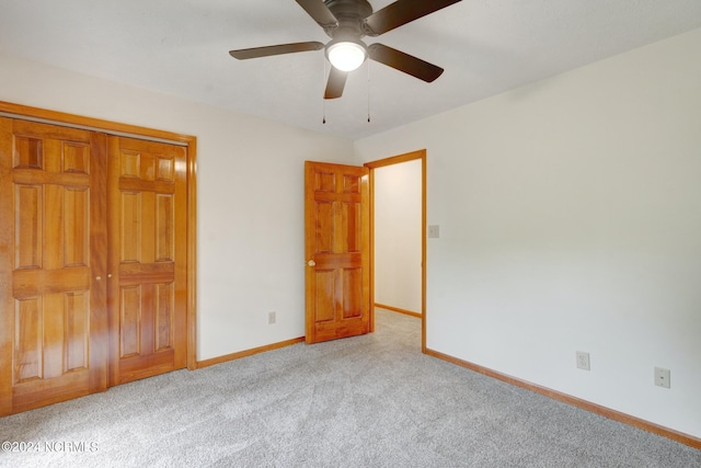 unfurnished bedroom featuring ceiling fan, a closet, and light colored carpet