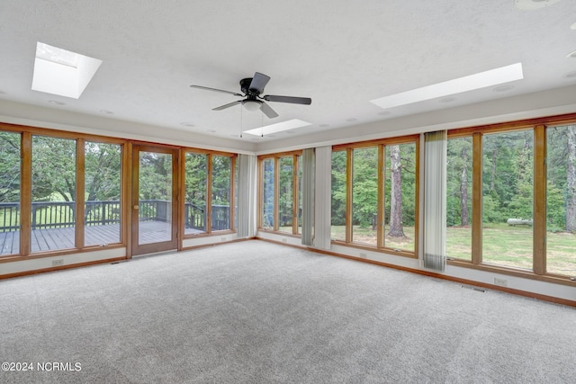 unfurnished sunroom with ceiling fan and a skylight