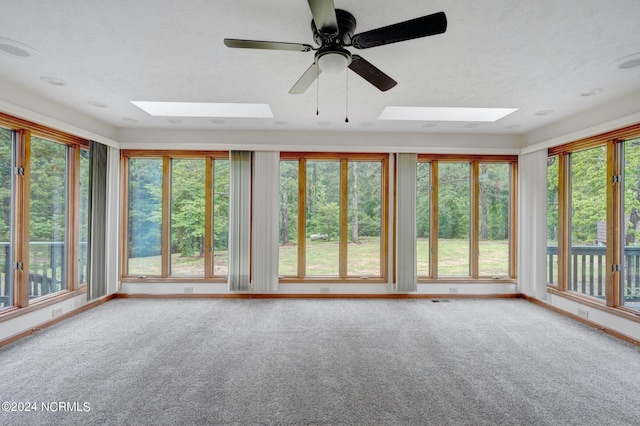 unfurnished sunroom featuring ceiling fan and a skylight