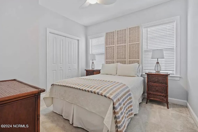 carpeted bedroom featuring ceiling fan and a closet