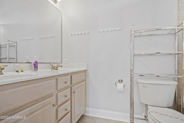 bathroom with tile patterned flooring, vanity, and toilet