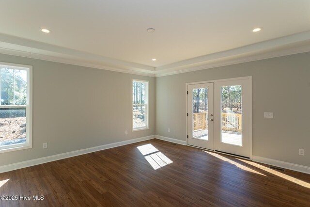 empty room featuring dark hardwood / wood-style flooring, french doors, crown molding, and a tray ceiling