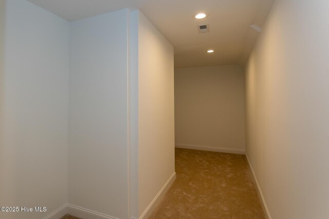 unfurnished bedroom with connected bathroom, a closet, a walk in closet, and light colored carpet