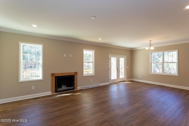 unfurnished living room with a chandelier, ornamental molding, and dark wood-type flooring