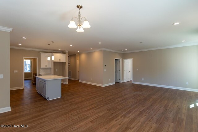 unfurnished living room with crown molding, dark wood-type flooring, and a healthy amount of sunlight