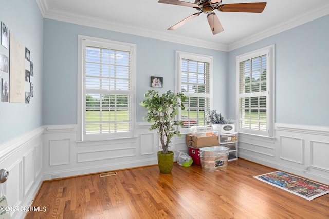 doorway to outside with wainscoting, wood finished floors, and visible vents