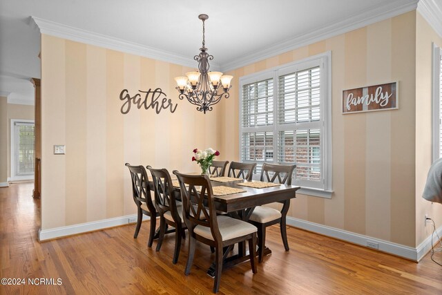 dining space featuring wallpapered walls, baseboards, wood finished floors, and ornamental molding