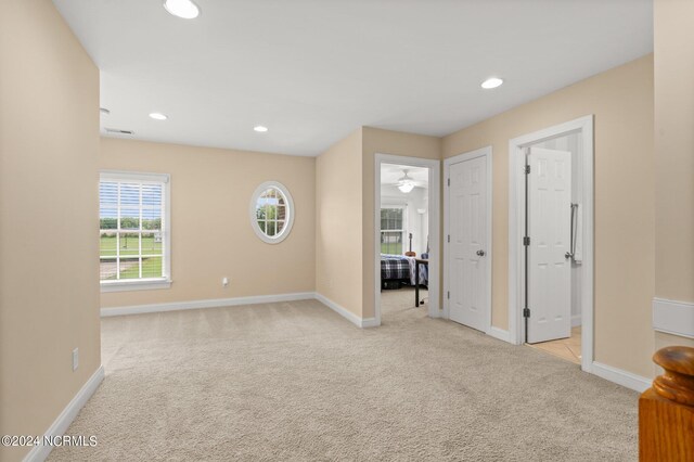 spare room featuring light carpet, baseboards, and recessed lighting