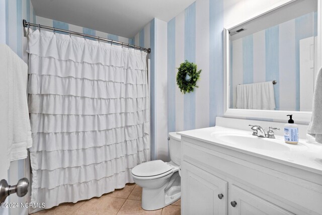 bathroom with curtained shower, wallpapered walls, toilet, vanity, and tile patterned floors