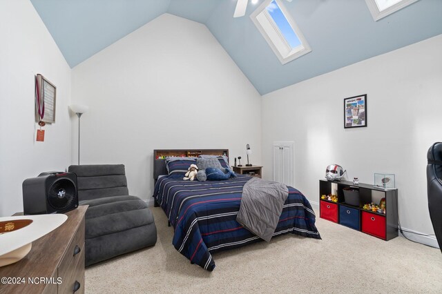 bedroom with high vaulted ceiling, a skylight, carpet flooring, and a ceiling fan