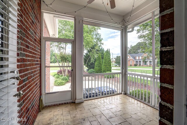 unfurnished sunroom featuring ceiling fan