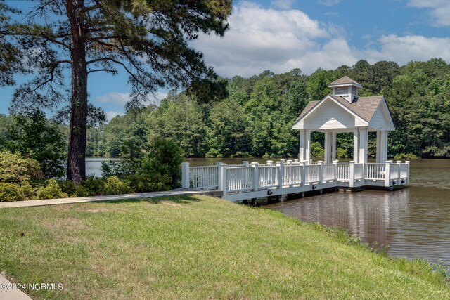 dock area featuring a water view, a yard, a view of trees, and a gazebo