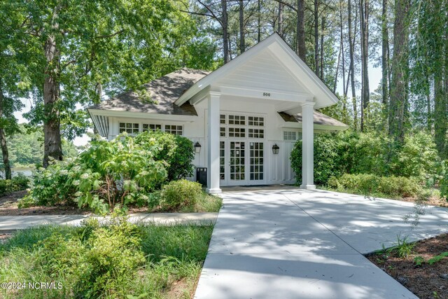 view of front of property with roof with shingles and french doors