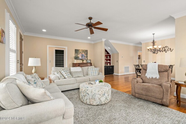 living room with baseboards, visible vents, wood finished floors, and ornamental molding