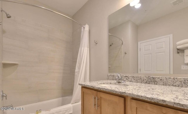 bathroom with large vanity and shower / tub combo