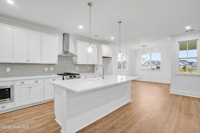 1320 Trisail Ter, Wilmington, NC 28412 - kitchen with a sink, light countertops, wall chimney exhaust hood, stainless steel microwave, and tasteful backsplash