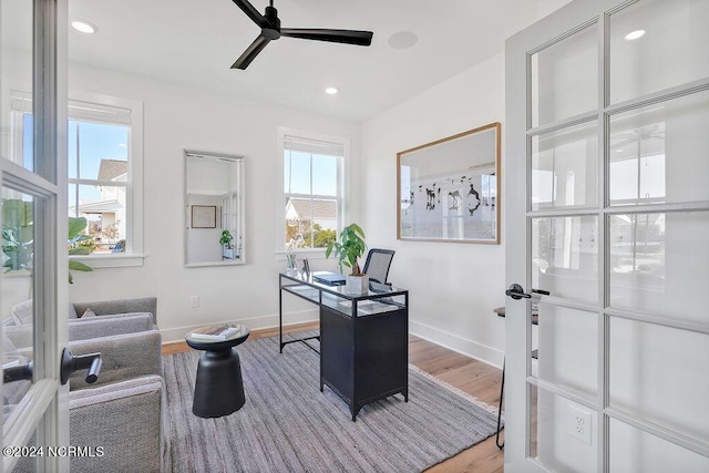 home office featuring a healthy amount of sunlight, ceiling fan, and hardwood / wood-style floors