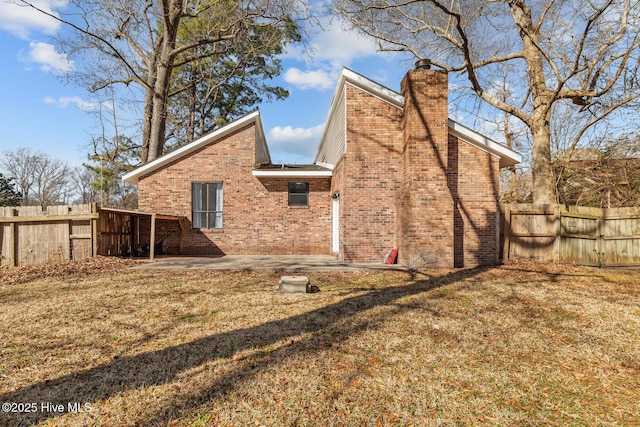 back of house featuring a patio and a yard