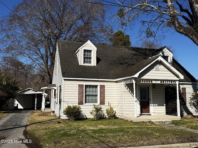 new england style home with a front yard and driveway