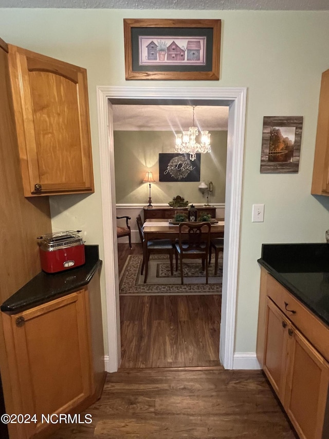 interior space featuring a chandelier, dark wood finished floors, and baseboards