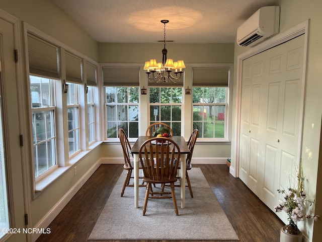 dining space featuring a textured ceiling, dark wood-style flooring, a wall mounted air conditioner, and an inviting chandelier