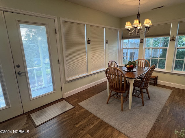 dining space featuring a chandelier, dark wood-style flooring, visible vents, and baseboards