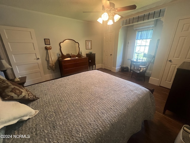 bedroom with a ceiling fan, crown molding, baseboards, and dark wood-type flooring