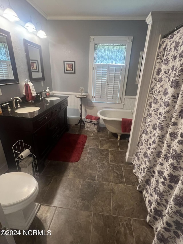 full bathroom with double vanity, a wainscoted wall, ornamental molding, and a sink