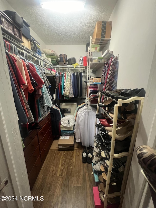 spacious closet with dark wood-style flooring