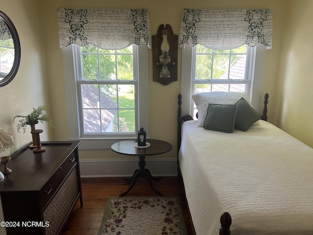 bedroom featuring baseboards and dark wood-style flooring