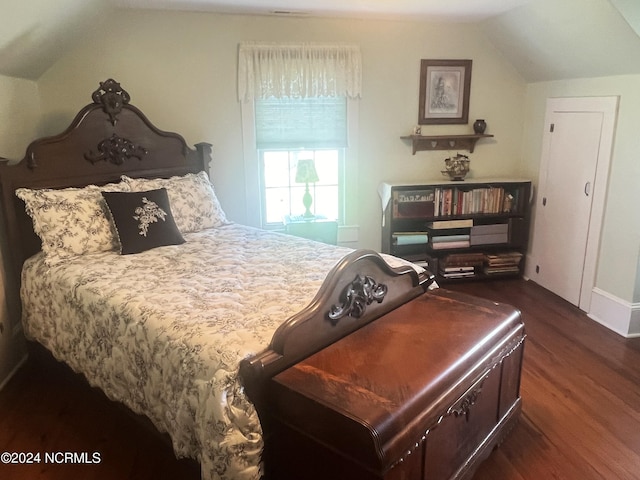 bedroom featuring lofted ceiling and dark wood finished floors