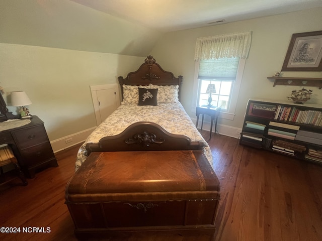 bedroom with dark wood-type flooring, visible vents, vaulted ceiling, and baseboards