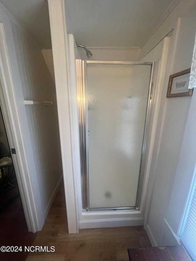 full bath with wood finished floors and a shower stall