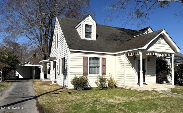 view of front facade with aphalt driveway, a front yard, and a shingled roof