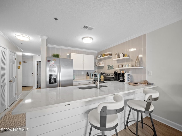 kitchen with backsplash, appliances with stainless steel finishes, and kitchen peninsula