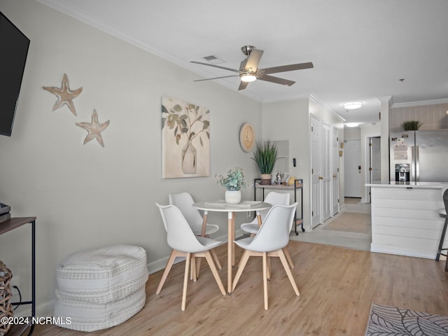 dining area featuring ceiling fan, light hardwood / wood-style flooring, and crown molding