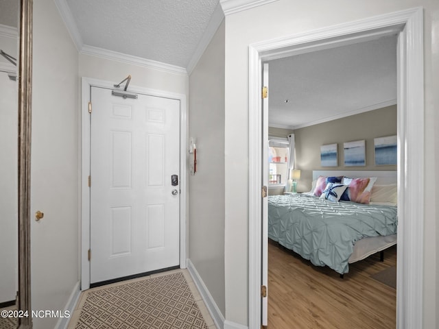 bedroom with hardwood / wood-style flooring, ornamental molding, and a textured ceiling