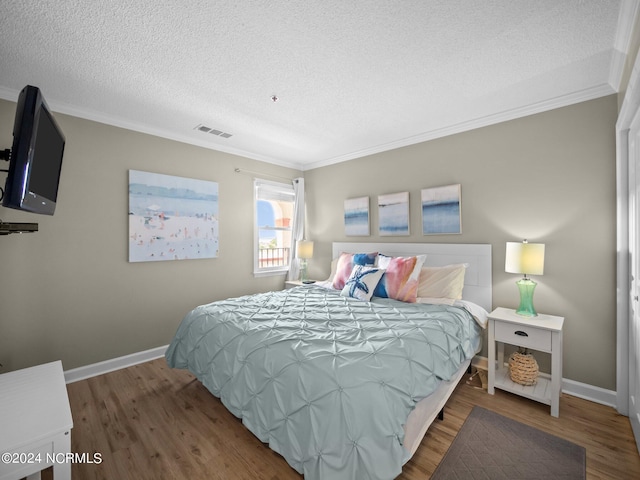 bedroom featuring hardwood / wood-style flooring, ornamental molding, and a textured ceiling