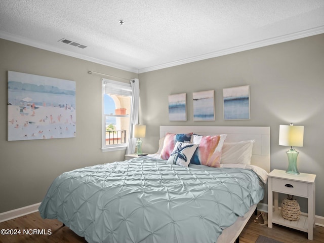 bedroom with ornamental molding, a textured ceiling, and dark hardwood / wood-style floors