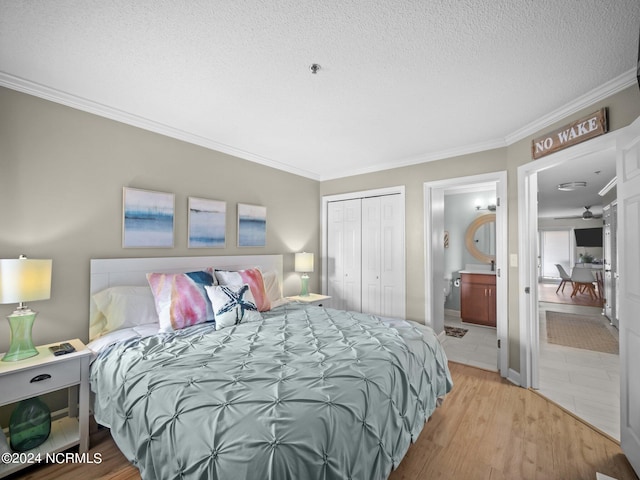 bedroom featuring hardwood / wood-style floors, connected bathroom, ornamental molding, and a closet