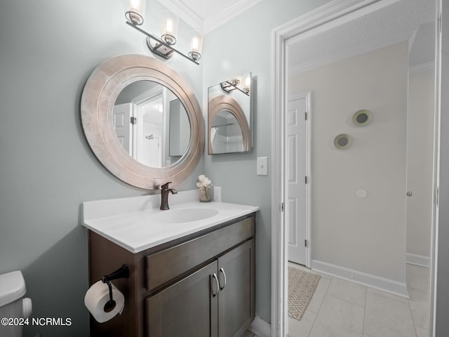 bathroom with crown molding, tile flooring, toilet, and vanity with extensive cabinet space