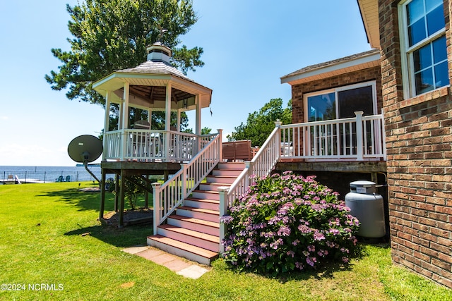 exterior space featuring a lawn, a water view, and a gazebo