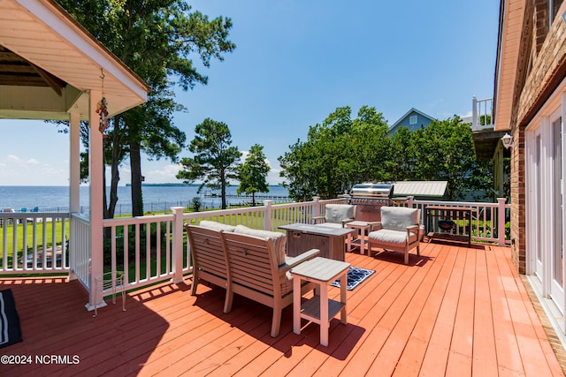 wooden terrace featuring outdoor lounge area and a water view