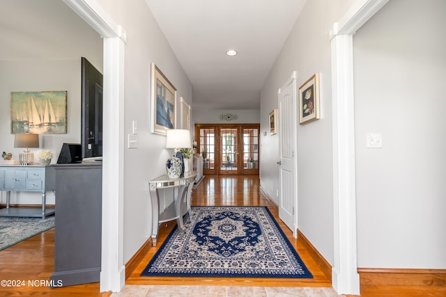 hallway with wood-type flooring and french doors